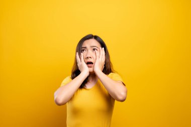 Kadın, sarı arka planda yalnız kalmaktan korkuyor.