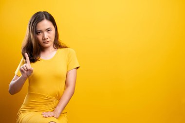 İzole edilmiş sarı arka planda dur işareti yapan kadın