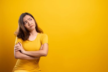 Sarı arka planda kendini yalnız hisseden kadın.