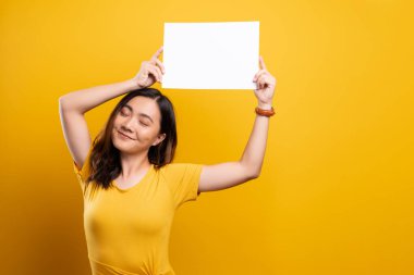Sarı arkaplan üzerinde kağıt kopyalama alanı gösteren kadın