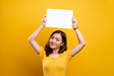 Sarı arkaplan üzerinde kağıt kopyalama alanı gösteren kadın