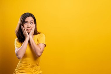 Sarı arka planda kendini yalnız hisseden kadın.