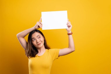 Sarı arkaplan üzerinde kağıt kopyalama alanı gösteren kadın