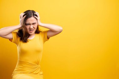 Kızgın kadın sarı arka planda izole bir şekilde çığlık atıyor.