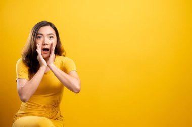 Kadın, sarı arka planda izole edilmiş dedikodu hareketi yapıyor.