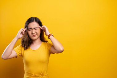 Kadının baş ağrısı sarı arka planda izole edilmiş.