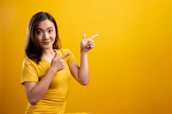 Mujer señalando espacio de copia aislado sobre fondo amarillo —  Fotos de Stock
