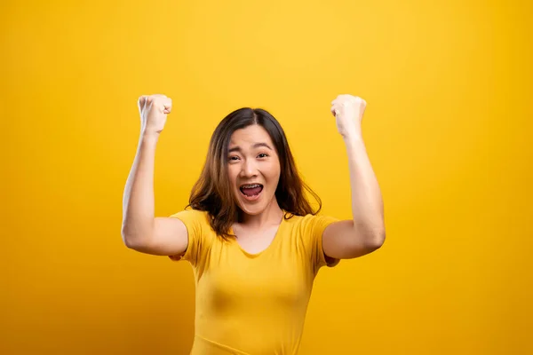 Ευτυχισμένη γυναίκα κάνει χειρονομία νίκης απομονώνονται πάνω από κίτρινο φόντο — Φωτογραφία Αρχείου