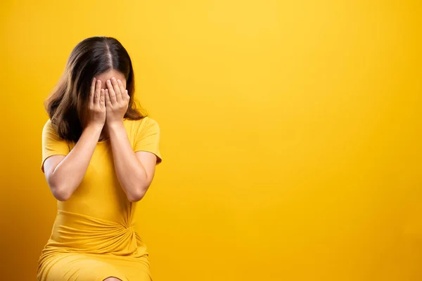 Droevige vrouw geïsoleerd over gele achtergrond — Stockfoto