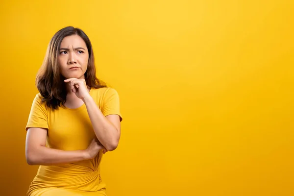 Frau fühlt sich vor gelbem Hintergrund verwirrt — Stockfoto