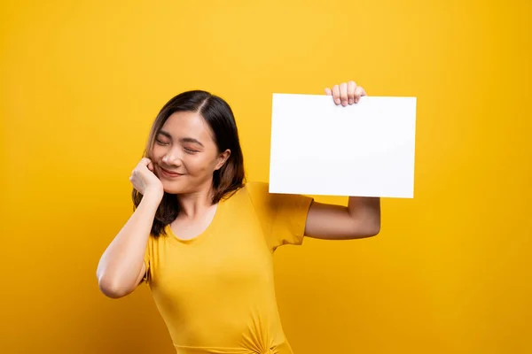 Woman showing paper copy space isolated over yellow background — Stock Photo, Image