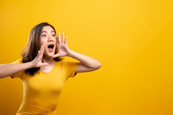 Happy woman making shout gesture isolated over yellow background — ストック写真