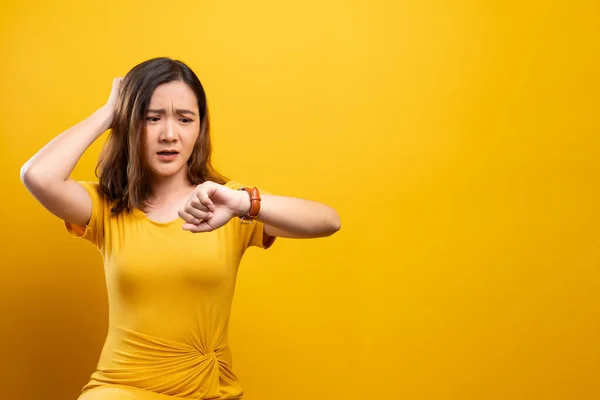 Mujer sorprendida cogida de la mano con reloj de pulsera aislado en un amarillo — Foto de Stock
