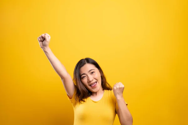 Szczęśliwa kobieta zrobić zwycięski gest izolowane na żółtym tle — Zdjęcie stockowe