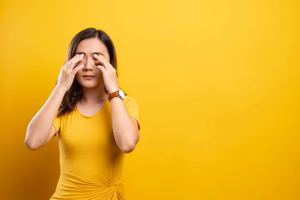 Woman has eyes pain isolated over yellow background — Stock Photo, Image