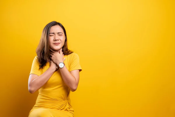 Mulher tem dor de garganta isolada sobre fundo amarelo — Fotografia de Stock