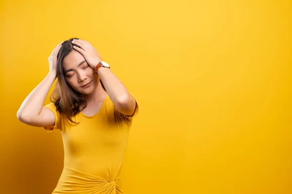 Vrouw heeft hoofdpijn geïsoleerd over gele achtergrond — Stockfoto