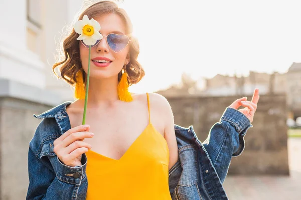 花を保持する美しい女性の明るい肖像画 黄色のドレス デニムジャケット ヒップスタースタイル 夏のファッショントレンド トレンディーなサングラス — ストック写真