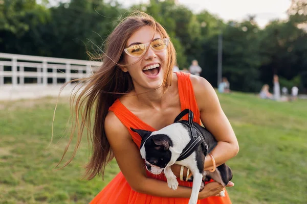 公園で犬と遊ぶ楽しいオレンジのドレスの若い幸せな笑顔の女性 夏のスタイル 陽気な気分 — ストック写真