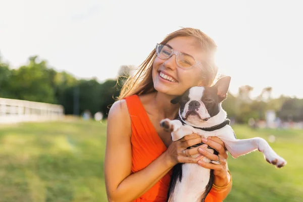 公園で犬と遊ぶ楽しいオレンジのドレスの若い幸せな笑顔の女性 夏のスタイル 陽気な気分 — ストック写真