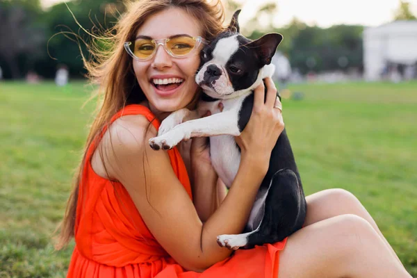 公園で犬と遊ぶ楽しいオレンジのドレスの若い幸せな笑顔の女性 夏のスタイル 陽気な気分 — ストック写真