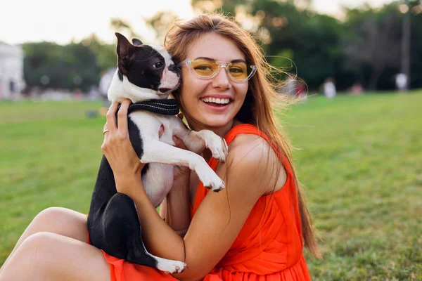 公園で犬と遊ぶ楽しいオレンジのドレスの若い幸せな笑顔の女性 夏のスタイル 陽気な気分 — ストック写真