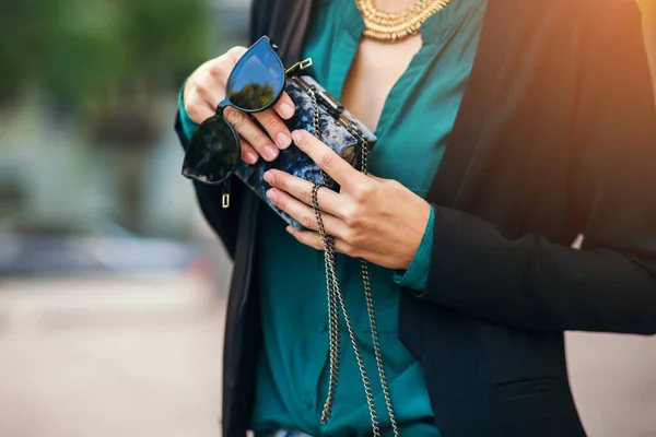 緑のブラウスとジャケットの魅力的なスタイリッシュな女性 エレガントなスタイル 夏のファッショントレンド 通りを歩く 財布のサングラスを保持 — ストック写真