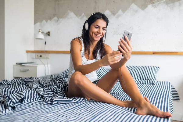 Jovem Mulher Morena Atraente Sentada Cama Pijama Sorrindo Quarto Emoção — Fotografia de Stock