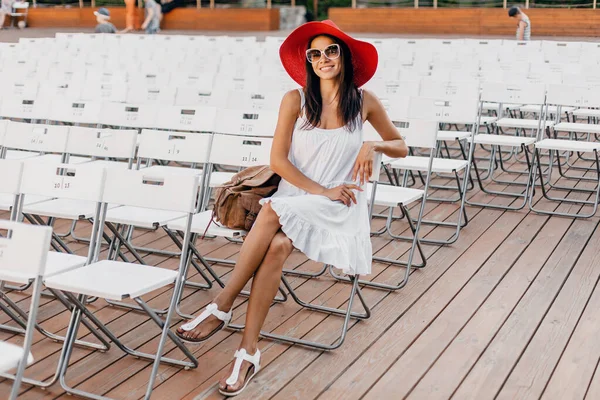 Atraktivní Žena Oblečená Bílých Šatech Červený Klobouk Sluneční Brýle Sedí — Stock fotografie