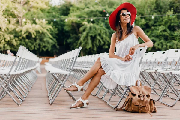 Atraktivní Žena Oblečená Bílých Šatech Červená Čepice Sluneční Brýle Sedí — Stock fotografie
