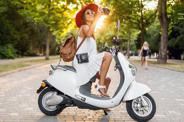 ストリートバイクに乗って魅力的な女性 夏休みのスタイル 楽しみを持っています スタイリッシュな衣装 ヴィンテージフォトカメラで写真を撮る — ストック写真