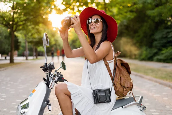 ストリートバイクに乗って魅力的な女性 夏休みのスタイル 楽しみを持っています スタイリッシュな衣装 ヴィンテージフォトカメラで写真を撮る — ストック写真