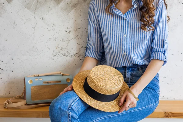 Νεαρή Ελκυστική Κομψή Γυναίκα Κάθεται Φόντο Τοίχου Κρατώντας Ψάθινο Καπέλο — Φωτογραφία Αρχείου