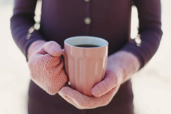 Pembe eldivenleri fincan sıcak çay veya kahve ile tutan kadın elinde. Yakın çekim. Kış ve Noel zaman kavramı — Stok fotoğraf