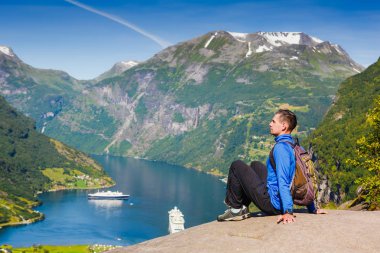 Pitoresk Norveç dağ manzarası. Genç adam manzarayı yakınındaki Geiranger fiyort, Norveç