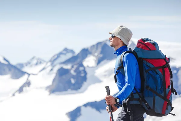 Hiker med ryggsäck stående på toppen av ett berg och njuter tne utsikten — Stockfoto
