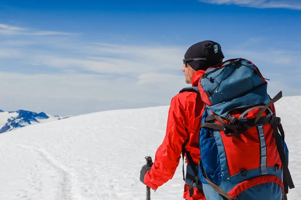 Caminhante com mochila em pé no topo de uma montanha e desfrutando de vista tne — Fotografia de Stock