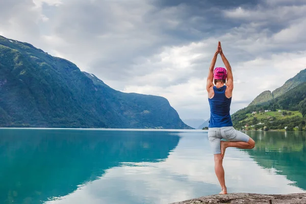 Mujer bonita practicando yoga en el lago — Foto de Stock