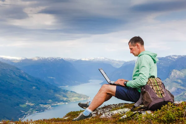 man working outdoors with laptop