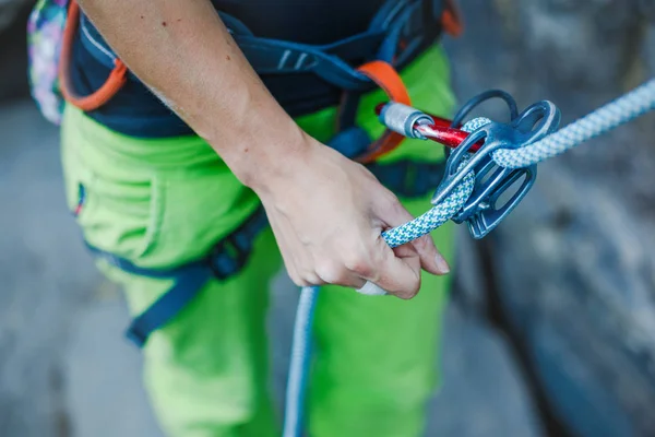 Alpinista de rocha usando chicotes de segurança e equipamento de escalada ao ar livre, imagem de close-up — Fotografia de Stock