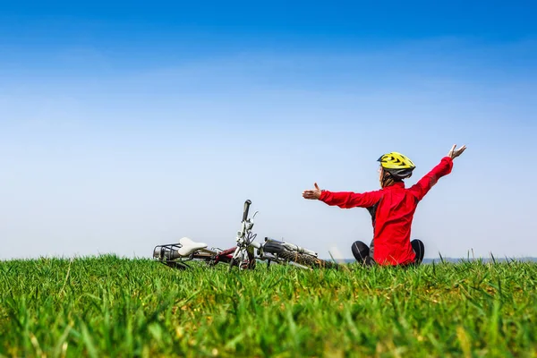 Felice ragazza attiva con la bicicletta godendo la vista su un prato verde — Foto Stock