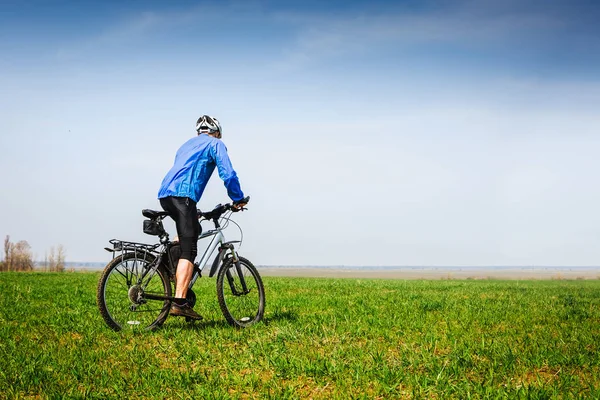 Fiatal kerékpáros kerékpározás a tavaszi parkban — Stock Fotó