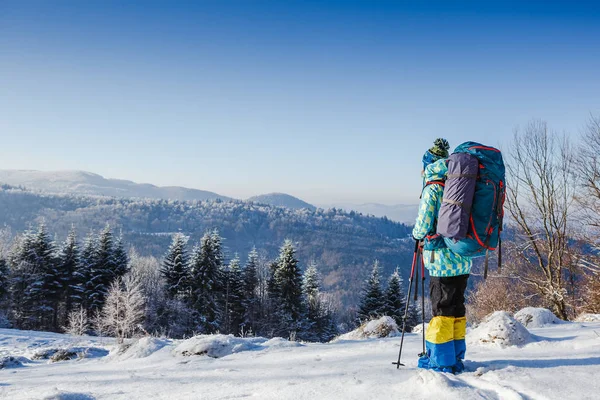 Turista com mochila em equipamento de inverno no fundo do céu claro — Fotografia de Stock