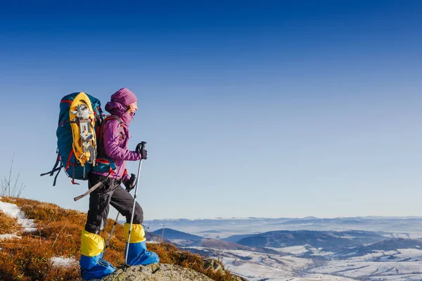 Turista con mochila en equipo de invierno sobre fondo cielo despejado — Foto de Stock