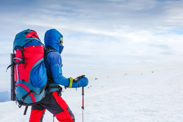 Путешественник с рюкзаком и зимней панорамой горы — стоковое фото