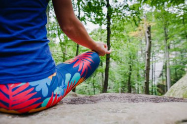 Ormanın içinde bir kaya üzerinde yoga yaparken meditasyon lotus poz, kadın