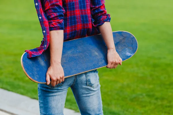 スケート ボードを手で保持して田舎道で内気な少女 — ストック写真