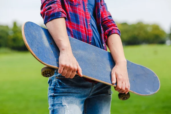 Hipster girl on rural road holding a skateboard in hands — Stock Photo, Image