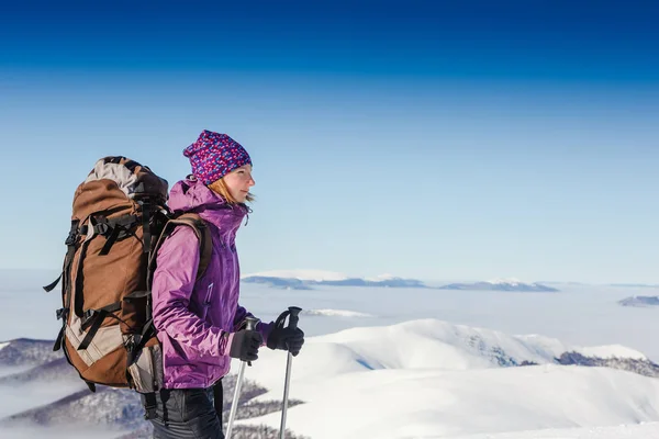 Mladá žena s batoh stojí proti zimním horském údolí - dobrodružství a cestování koncept — Stock fotografie