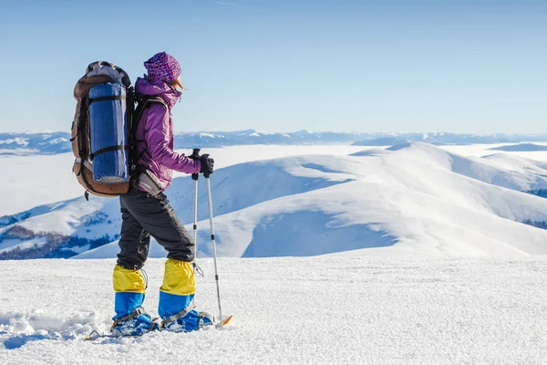 Mladá žena s batoh stojí proti zimním horském údolí - dobrodružství a cestování koncept — Stock fotografie